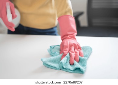 happy Female housekeeper service worker wiping table surface by cleaner product to clean dust. - Shutterstock ID 2270689209