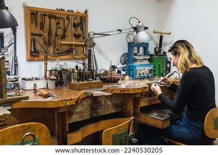 Happy female jeweler working in studio