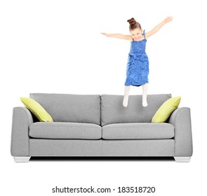 Happy Female Kid Jumping On Couch Isolated On White Background Shot With Tilt And Shift Lens