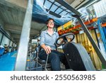 Happy female manual worker using forklift in a warehouse of a cnc metallurgic factory