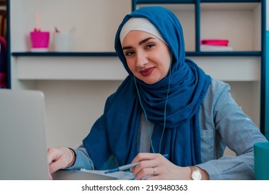 A Happy Female Muslim Adult In Hijab Using A Laptop For Online Education Or Video Call Business Meeting.