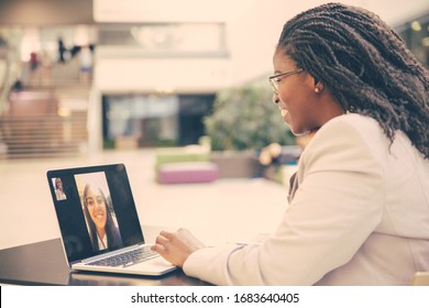 Happy female office friends talking through video call. Business women using digital devices for video chat. Internet connection concept
