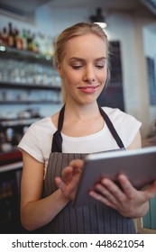 Happy female owner using digital tablet at coffee shop - Shutterstock ID 448621054