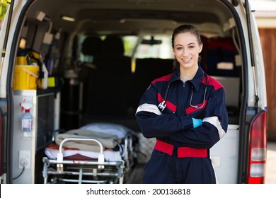 Happy Female Paramedic Standing In Front Of Ambulance