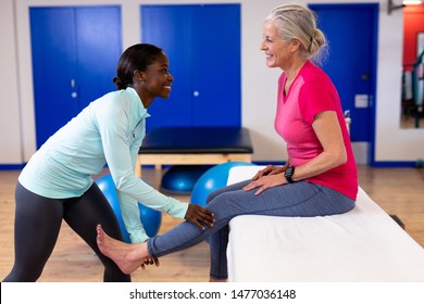 Happy female physiotherapist giving leg massage to active senior woman in sports center. Sports Rehab Centre with physiotherapists and patients working together towards healing - Powered by Shutterstock