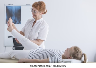 Happy Female Physiotherapist Working With Patient In Pediatric Scoliosis Clinic