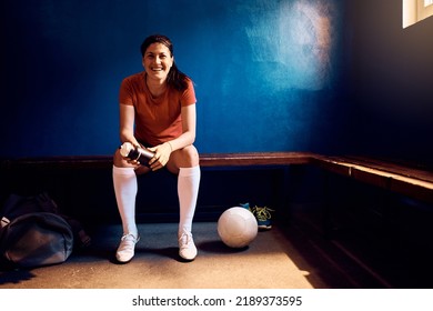 Happy female player in soccer dressing room looking at camera. Copy space. - Powered by Shutterstock