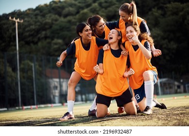 Happy Female Players Celebrating After Winning Soccer Match At The Stadium.