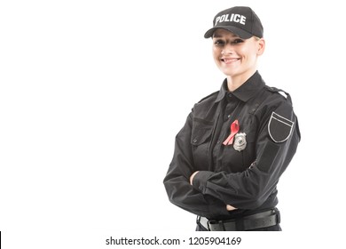 Happy Female Police Officer With Aids Awareness Red Ribbon Looking At Camera With Crossed Arms Isolated On White