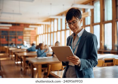 Happy female professor using touchpad in classroom at high school. Copy space. - Powered by Shutterstock