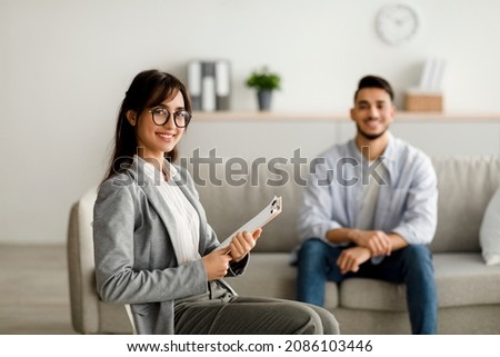 Happy female psychologist and young arab man smiling after effective therapy at office, free space. Confident psychotherapist on session with middle eastern guy. Successful treatment Foto stock © 