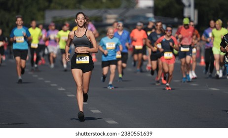 Happy female runner jog sport marathon. Smiling sportswoman work out public park. Woman athlete fast run long distance. Jogger fit body train. Girl sprint slow motion. City arena. Active life concept. - Powered by Shutterstock