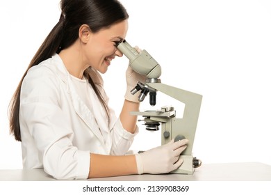 Happy Female Scientist Looking Through A Microscope, White Background