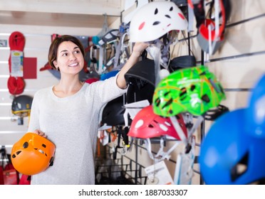 Happy Female Shopper Making A Helmet At A Sporting Goods Store