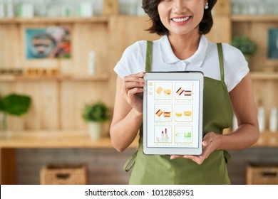 Happy Female Small Business Woner Showing Tablet With Website Of Her Handmade Soap Shop On The Screen