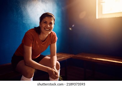 Happy female soccer player relaxing in locker room looking at camera. Copy space.  - Powered by Shutterstock