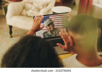 Happy Female Soldier Smiling Cheerfully While Video Calling Her Husband And Children From The Military Base. American Military Family Communicating Online.