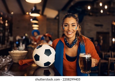 Happy Female Sports Fan Drinking Beer During Football World Championship In Pub And Looking At Camera.