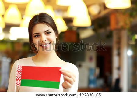 Happy female student holding flag of belarus
