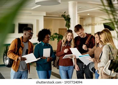 Happy female student showing test results to her friends while standing in a lobby.  - Shutterstock ID 1937724094