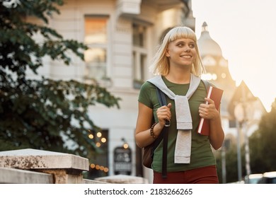 Happy Female Student Walking Through The City And Looking Away.