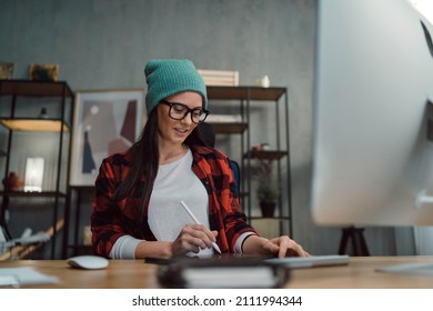 Happy Female Video Editor Works Indoors In Creative Office Studio.