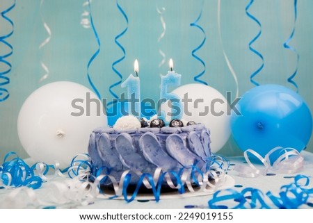 Happy fifteenth birthday card with navy cake and number fifteen candle with blue and white air balloons and decoration