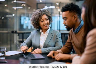 Happy financial advisor and African American couple using laptop on a meeting in the office. - Shutterstock ID 2292142101