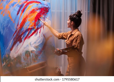 Happy fine artist painting on large canvas in art workshop. Modern artwork paint on canvas, creative, contemporary and successful fine art artist drawing masterpiece - Powered by Shutterstock