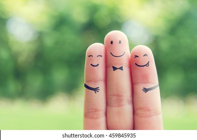 Happy finger art family group loving mother   father and son while smiley face at blurred outdoor park background  Retro filter effect  copy space 