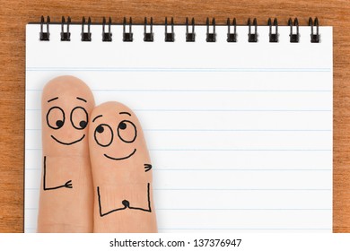 Happy Finger Face Couple With Blank Notepad For Copy Space 