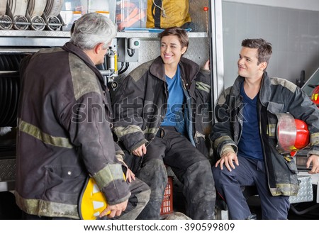 Happy Firefighters Conversing By Firetruck