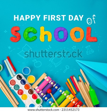 Happy first day of school background. Top view flat lay concept. Childish lettering, colored paper, supplies, stationery for primary school, elementary school or grade school educational.