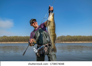 Happy fisherman with big zander. Success walleye fishing at wild river