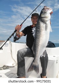 Happy  fisherman holding a sea bass