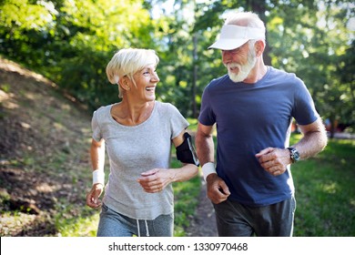 Happy Fit Senior Couple Exercising In Park