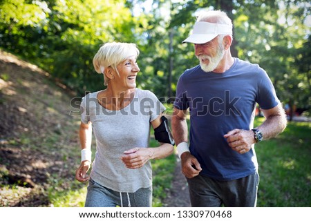 Happy fit senior couple exercising in park