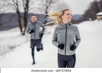 Happy Fit Sportswoman Racing Her Friend In Nature At Snowy Winter Day. Fitness Together, Outdoor Fitness, Winter Fitness