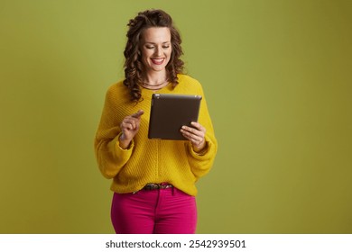 happy fit woman isolated on green background in yellow sweater using digital tablet. - Powered by Shutterstock