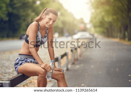 Happy fit woman taking a break from jogging