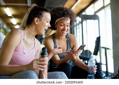 Happy fit women, friends smiling, talking and taking photos after work out in gym. Social media. - Shutterstock ID 2202091605