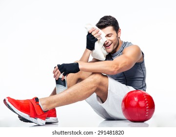 Happy Fitness Man Resting On The Floor Isolated On A White Background