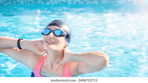 Happy fitness senior woman (over age of 50) in sport goggles, cap relaxing and enjoying sunny summer day after water aerobics at swimming pool. Mature female smiling. Healthy lifestyle. Copy space. - Powered by Shutterstock