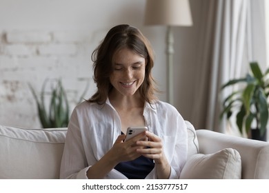 Happy focused on smartphone girl receiving message with good news, enjoying online chat, shopping on Internet, watching video, suffering from digital gadget, social media addiction - Powered by Shutterstock