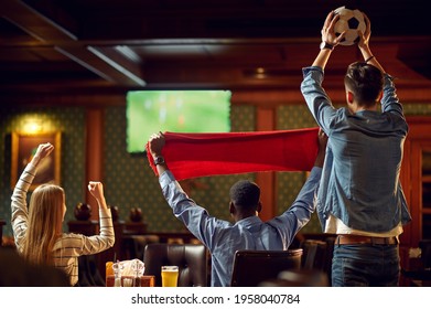 Happy Football Fans With Red Scarf And Ball In Bar