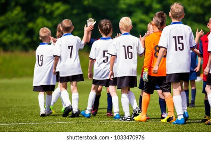 Happy Football Players Giving High Five At Field. Soccer Players High Five After Game. Two Teams High Five After the Weekly Match. Fair Play Rules in Youth Football - Powered by Shutterstock