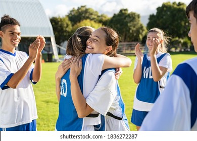 Happy football players hugging on field after scoring a goal. Soccer teammates embracing while players clapping hands on victory. Successful girl soccer players celebrating after winning the match. - Shutterstock ID 1836272287