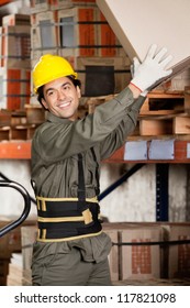Happy foreman lifting a cardboard box at warehouse - Shutterstock ID 117821098