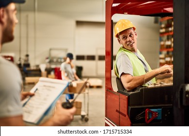 Happy Forklift Driver Communicating With Dispatcher In Industrial Warehouse. 