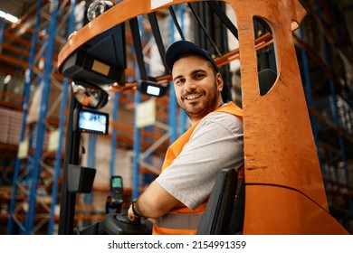 Happy forklift operator working at storage compartment and looking at camera. - Powered by Shutterstock